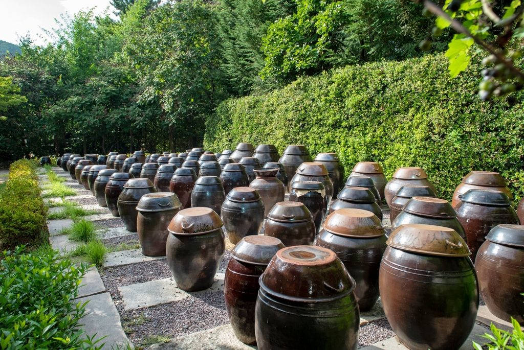 Traditional onggi jars arranged on a Korean jangdokdae, where ganjang and other fermented foods were kept.
