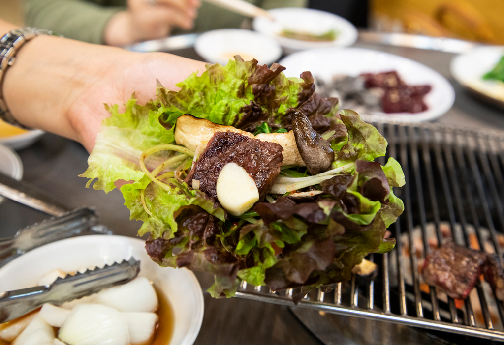 A bulgogi ssam (불고기쌈), with grilled beef, garlic, and scallions wrapped in lettuce.