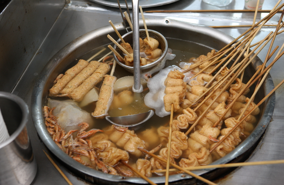 Eomuk skewers simmer in a pot of hot broth at a Korean street stall.