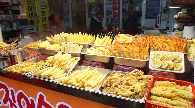 A market stall displays trays of assorted twigim.