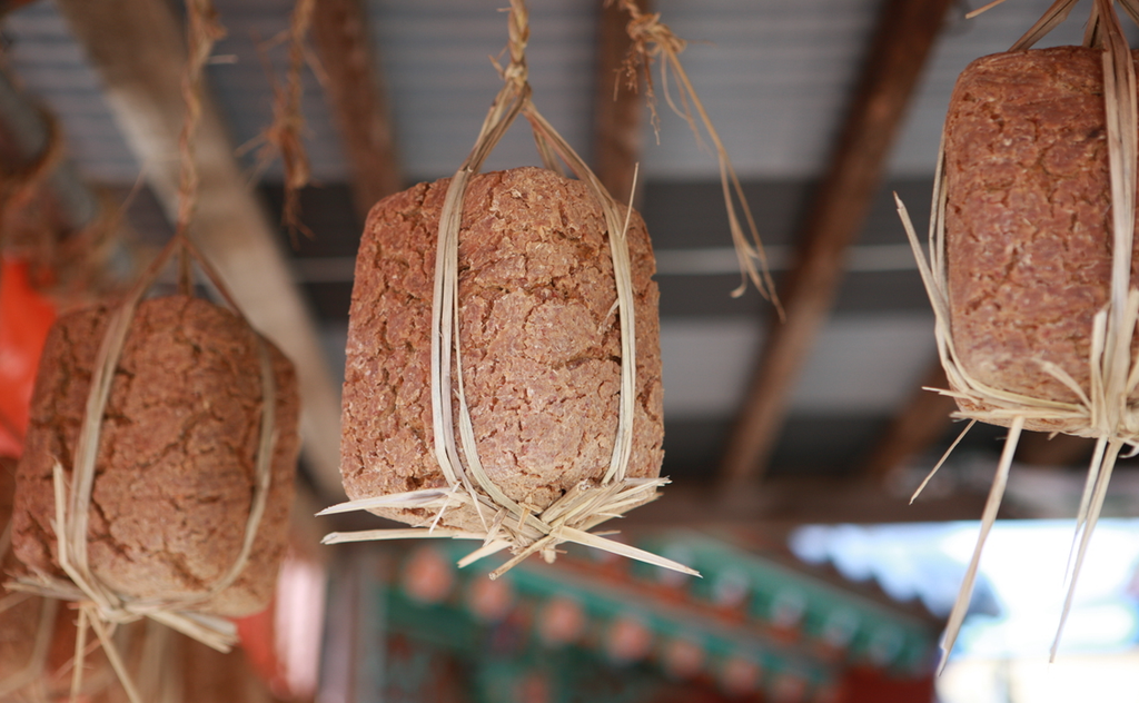 Meju (메주), fermented soybean blocks used to make doenjang and ganjang, hang to dry in a traditional Korean setting.
