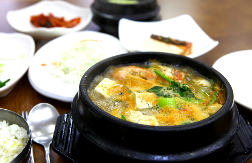 Doenjang jjigae (된장찌개) bubbles in a ttukbaegi (뚝배기), served with rice and banchan (반찬).
