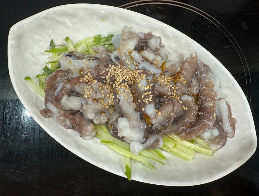Nakji-tangtangi (낙지탕탕이), made by chopping live octopus; the pieces may still wriggle when served with cucumber and sesame seeds.