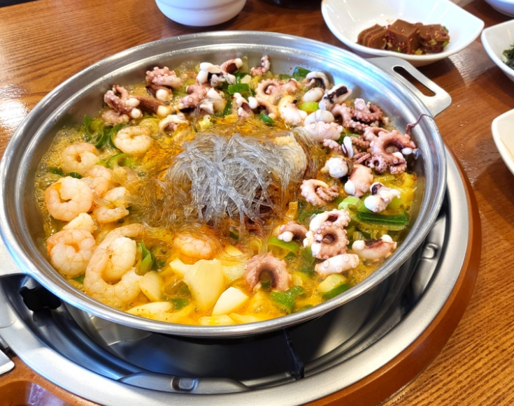 Nakgopsae (낙곱새), a spicy Korean hot pot with octopus, beef small intestine, shrimp, vegetables, and glass noodles.